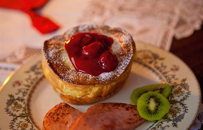 A German pancake with cherry pie filling on top